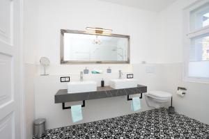 a bathroom with two sinks and a mirror and a toilet at Villa Primavera in Nesselwang