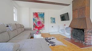 a living room with a couch and a fireplace at Villa Primavera in Nesselwang