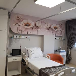 a hospital room with a bed and flowers on the wall at mutlu genç dur in Atakum