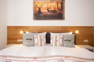 a bed with pillows and a painting on the wall at Bergliebe in Nesselwang