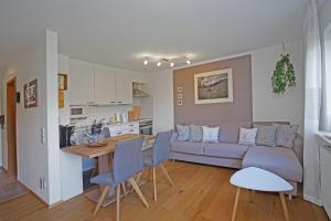 a living room and kitchen with a couch and a table at Bergliebe in Nesselwang