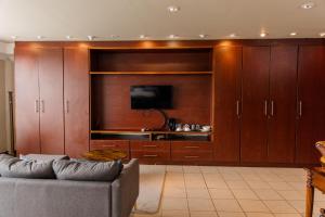 a living room with a couch and a flat screen tv at St Andrews exclusive guesthouse in Klerksdorp