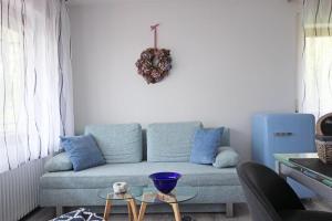 a living room with a couch with blue pillows at Am Mühlbach in Nesselwang +11 photos