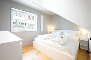 two white beds in a room with a window at Exclusive Maisonettewohnung! in Nesselwang