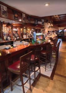 eine Bar in einem Restaurant mit Holztischen und -stühlen in der Unterkunft Feerick's Hotel in Rathowen