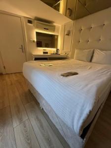 ein großes weißes Bett in einem Zimmer mit einem Spiegel in der Unterkunft The Constantine Hotel in Istanbul