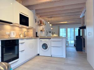 a kitchen with a washer and dryer in it at Ferienhaus Oceansounds in Sierksdorf
