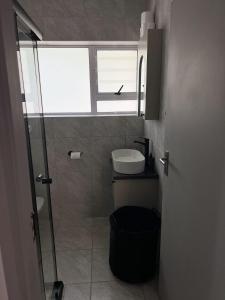 a small bathroom with a toilet and a window at Villa Bella in George