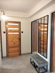 a room with a door and a bench and a mirror at Apartament SIEDEMNAŚCIE in Sanok