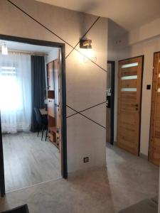 a room with a door open to a room with a table at Apartament SIEDEMNAŚCIE in Sanok