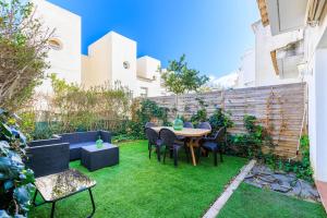 a garden with a table and chairs on grass at Cumbre in Salou