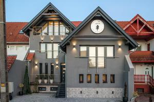 a house with a clock on the front of it at Greyhouse Apartments in Harkány