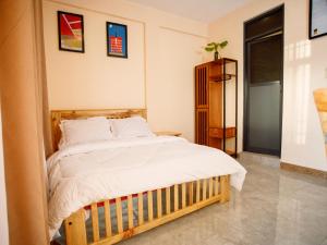 a bedroom with a large bed with white sheets at Kiliscape Hotel Moshi in Uru