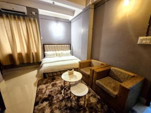 a room with a bed and a couch and a table at Luxe Haven Homestay 2A in Guwahati
