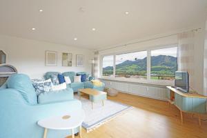 a living room with a blue couch and a tv at Panoramaweg in Wertach