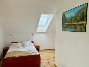 a bedroom with a bed and a painting on the wall at Willa u Marioli in Ściegny