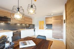 a kitchen with white cabinets and a wooden table at Panoramaweg in Wertach