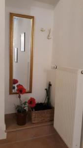 a mirror in a bathroom with flowers in a basket at Ferienhaus Wismar in Wismar