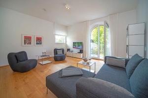 a living room with a blue couch and two chairs at Chalet am Breitenberg Apt1 in Pfronten