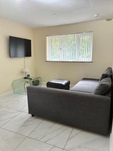 a living room with a couch and a television at Castell Cottages Central with Parking in Caerphilly