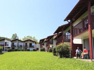 two people sitting in chairs outside of a building at B4 Vue Montagnes Piscine in Souraïde +5 photos