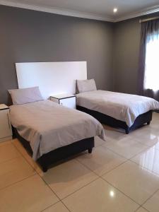 a bedroom with two beds and a window at Fumas guesthouse in Duvhapark