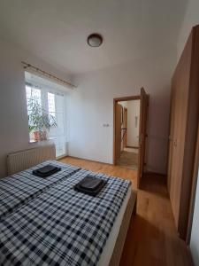 a bedroom with a bed with a checkered blanket on it at Apartmány pod Divadlem in Znojmo