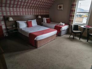 a hotel room with two beds and a table at Chieftain Hotel in Inverness