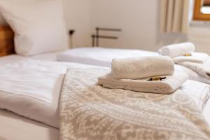 two white towels sitting on top of two beds at Freigeist in Nesselwang