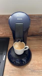 a coffee maker on aucer with a cup of coffee at Caprice des Dunes in Notre-Dame-de-Monts