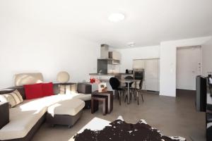 a living room with a white couch and a kitchen at N-Appartement Falkenstein in Nesselwang
