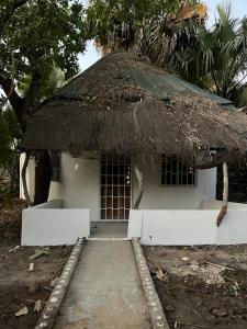 a small white building with a thatched roof at Tida-Ecolodge in Kartung