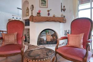 a living room with two chairs and a fireplace at Haus Bella in Schwangau