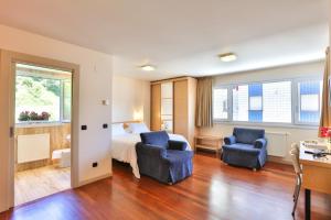 ムンダカにあるApartamentos Mundakaのベッド1台と椅子2脚が備わるホテルルームです。