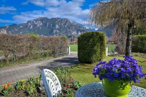 a vase of flowers on a table in a garden at Haus Bella in Schwangau +23 photos