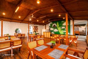a restaurant with wooden tables and chairs and a large screen at Monkey Tribe Alleppey in Alleppey +35 photos