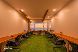 a conference room with chairs and a green carpet at Monkey Tribe Alleppey in Alleppey