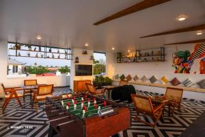 a living room with a ping pong table and chairs at Monkey Tribe Alleppey in Alleppey