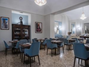 a dining room with tables and blue chairs at Vogue Hotel Arezzo in Arezzo