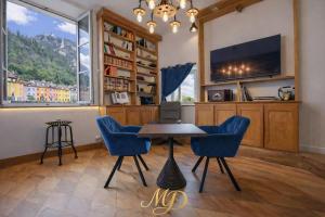 a dining room with a table and chairs and a tv at MYD - The Jules Verne in Grenoble