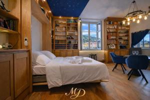 a bedroom with a bed and a desk and a window at MYD - The Jules Verne in Grenoble