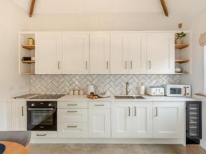 a white kitchen with white cabinets and appliances at 2 Bed in Bromyard oc-91816 in Collington +16 photos