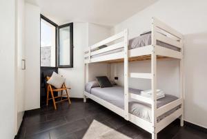 a bedroom with two bunk beds and a chair at Tramontana 28B by Escape Home in Fornells