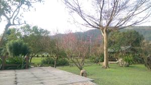 a wooden deck in a yard with a tree at Seasons Inn in Jiaoxi