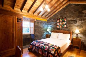 a bedroom with a bed and a window at Adegas do Pico in São Roque do Pico