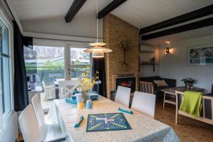 a dining room with a table and chairs and a room with a fireplace at M252-Vaeggerlose-Bjergfruevej-6 in Bøtø By