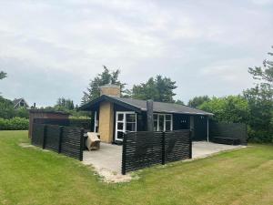 a small house with a fence in a yard at M252-Vaeggerlose-Bjergfruevej-6 in Bøtø By +11 photos