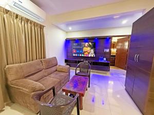 a living room with a couch and a tv at Hotel Fortune 36 in Bangalore