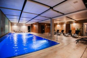 a large pool with blue water in a building at Hotel Kaskáda in Kuřim