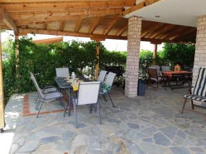 a patio with a table and chairs under a pavilion at Villa Belvedere Flogita in Flogita